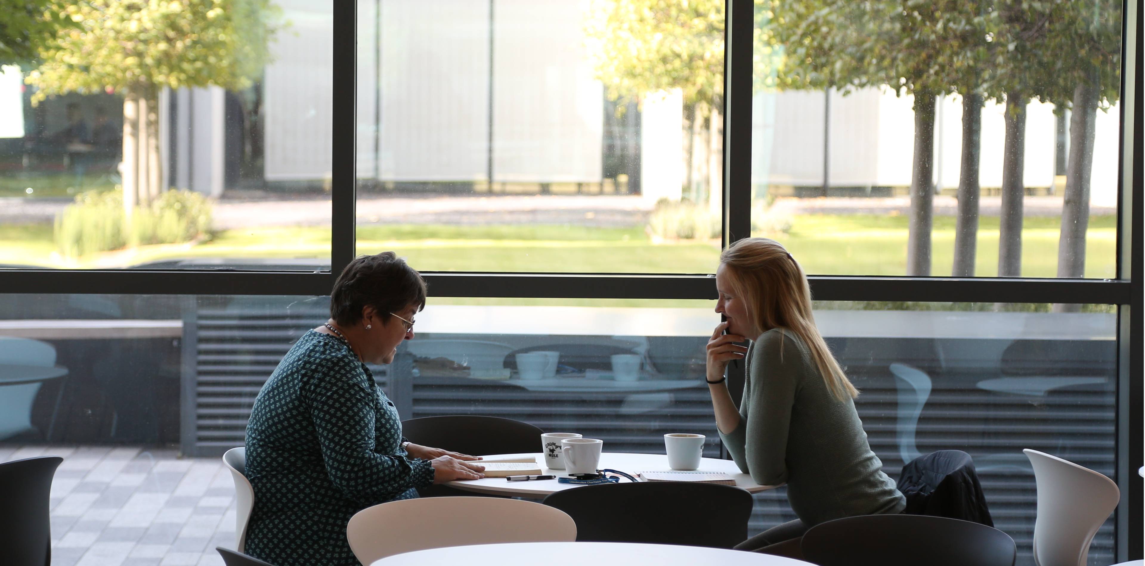 Two people talking in the Milner Cafe